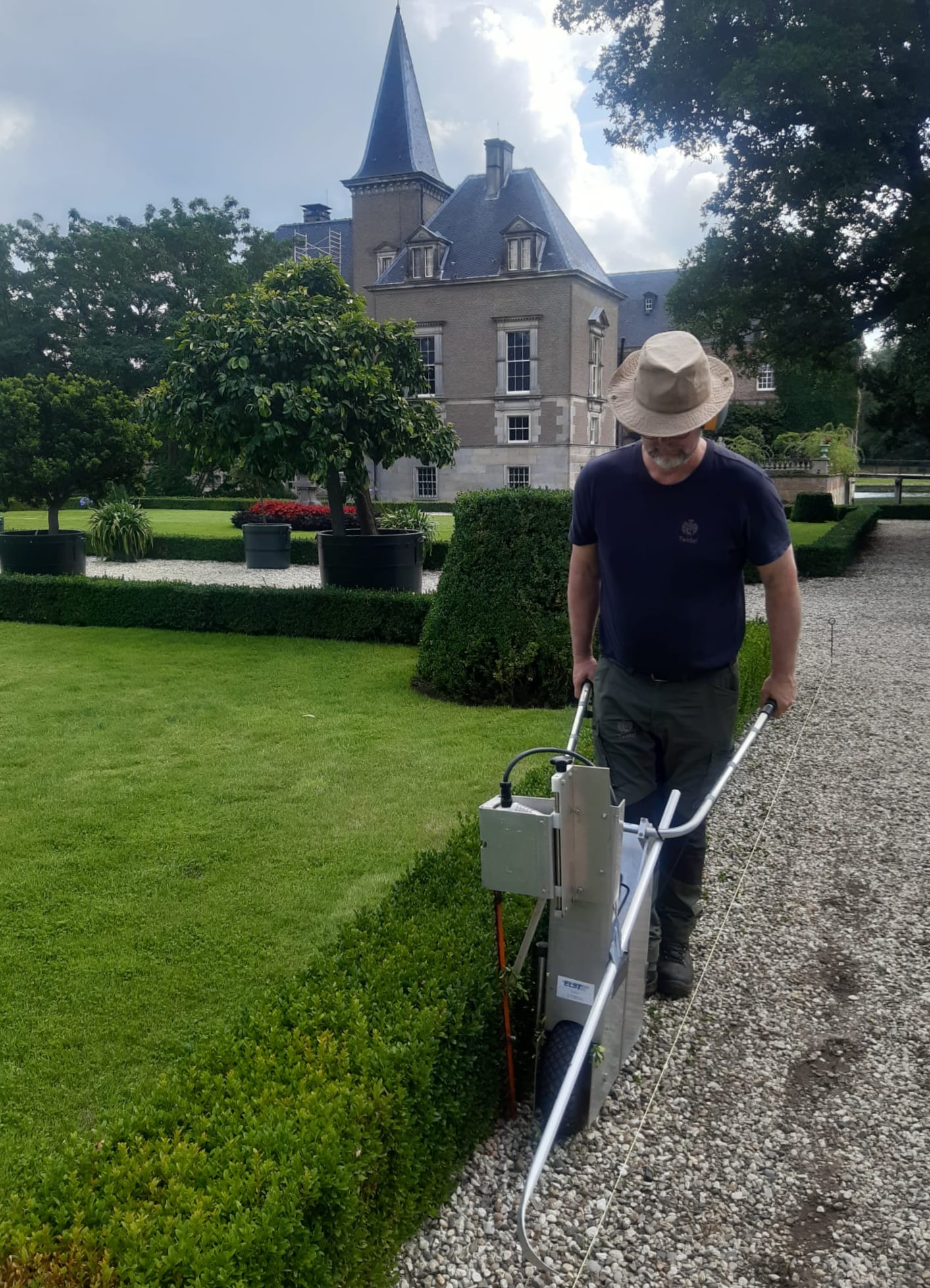 Zijkanten van de buxushaag snoeien bij kasteel Twickel